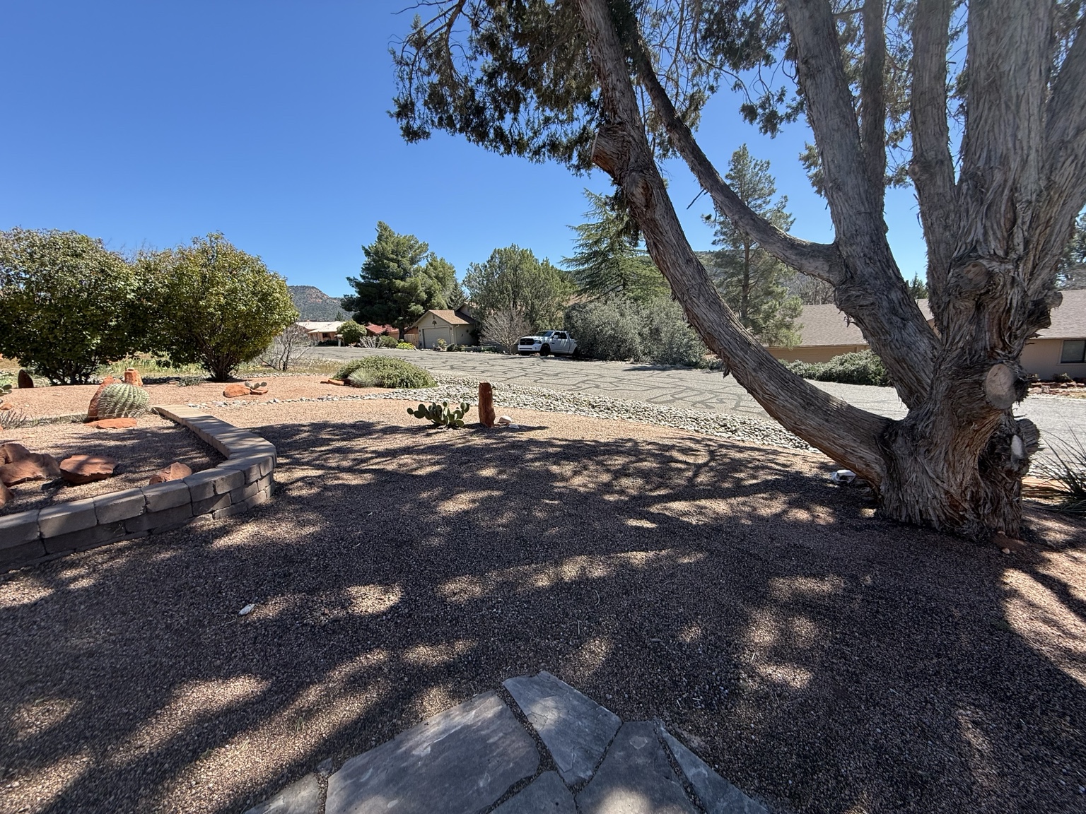 Maintained gravel landscape, mature trees, and stonework at a Sedona home