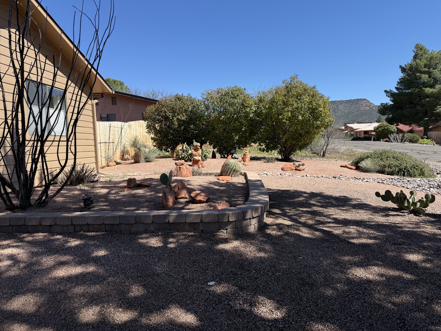 Cactus beds, clean gravel, and stone borders at a Sedona property